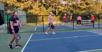 Another round of women competing on one court with a men's group on the second court.